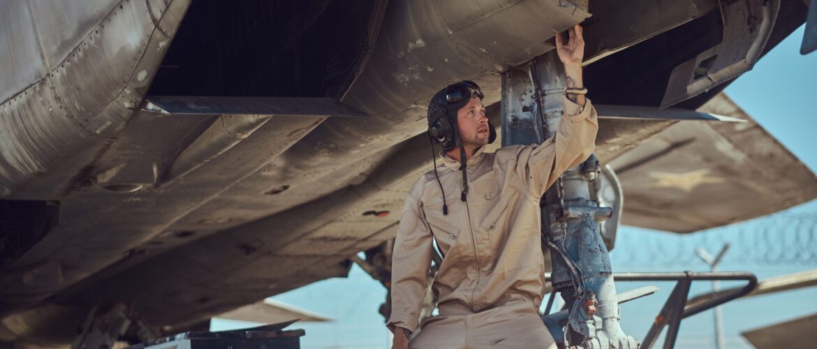 Luchtmacht monteurs onder een vliegtuig